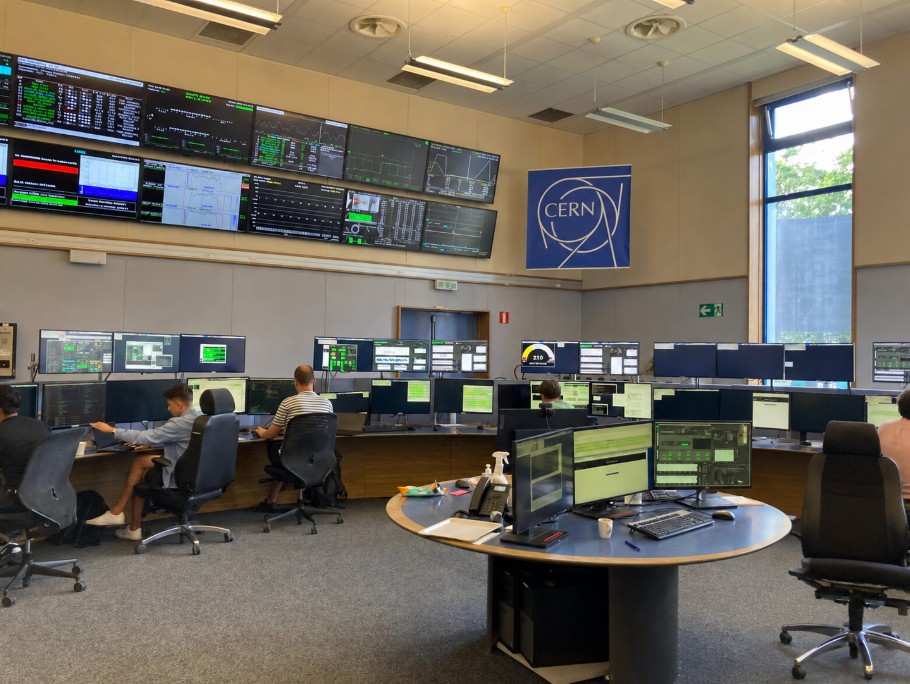 CERN control room with monitoring displays and computer workstations.